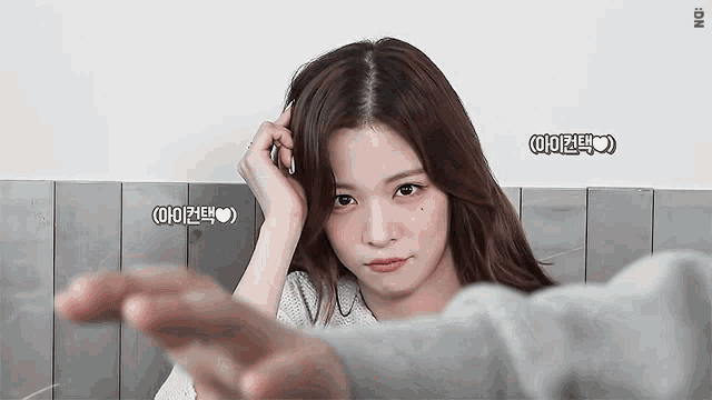 a woman 's hand is reaching out towards the camera with a heart in the corner