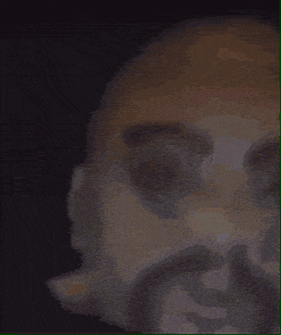 a man wearing glasses and a white jacket is standing in a dark room .