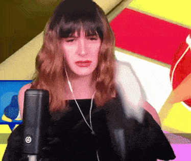 a woman wearing headphones and a black microphone with a s on it