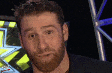 a man with a beard is standing in front of a sign that says wwe