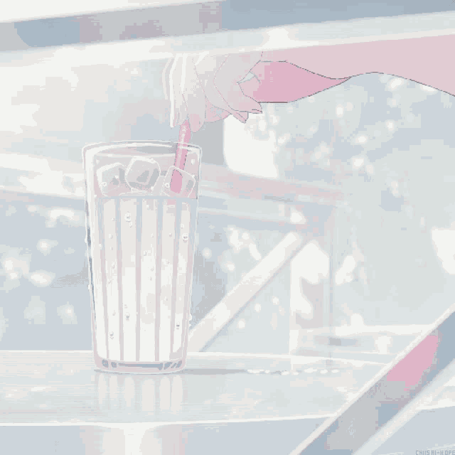a glass of milk with ice and a straw in it