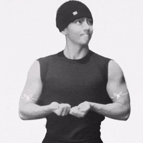 a man wearing a black tank top has a pair of scissors on his arms