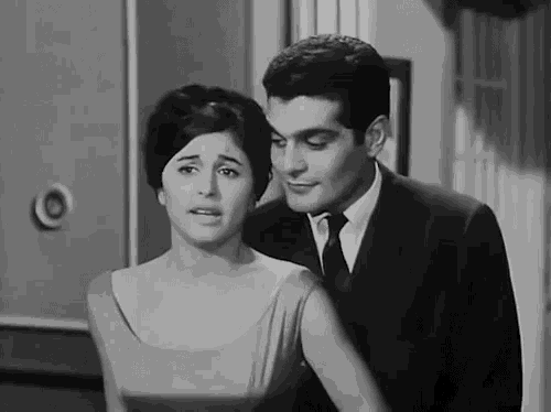 a man in a suit and tie is standing next to a woman in a dress .