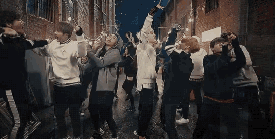 a group of people are dancing in an alleyway .