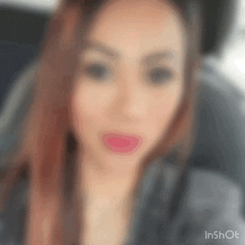 a blurry picture of a woman 's face with red lipstick on her lips .