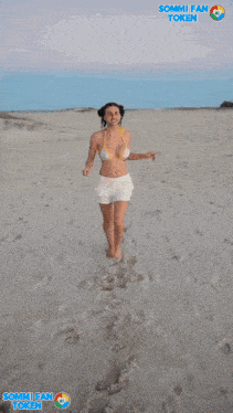 a man in a bikini and white skirt stands on a beach with sommi fan token on the bottom