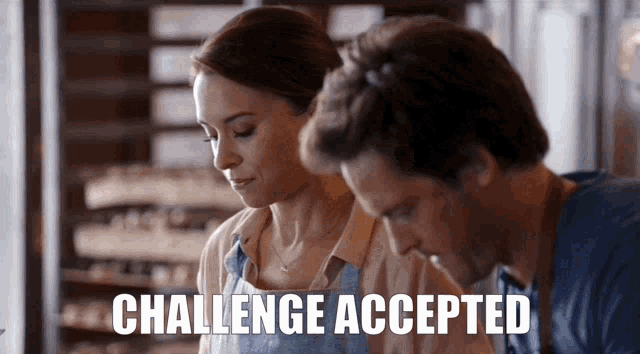 a man and a woman are working in a kitchen and the words challenge accepted are on the screen