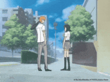 a boy and a girl standing next to each other on a street