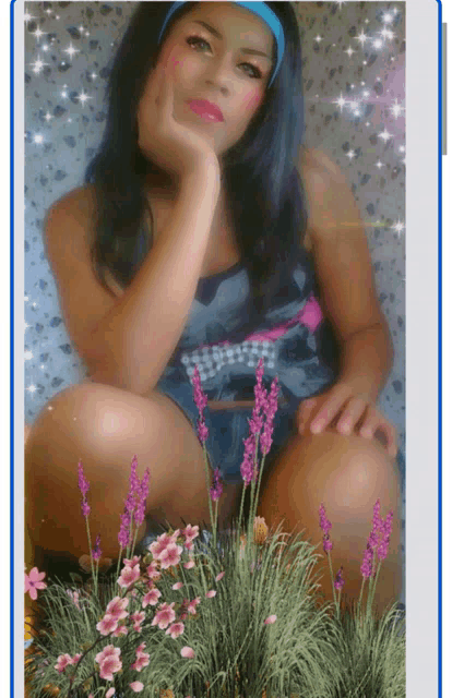 a woman is kneeling down with her hand on her chin in front of purple flowers