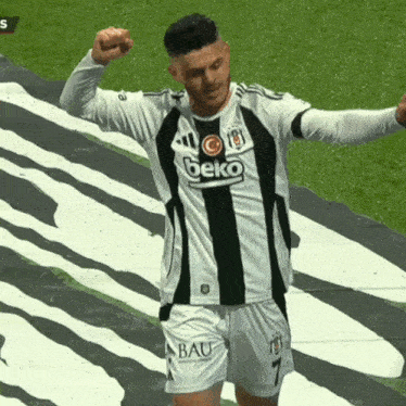 a soccer player wearing a beko shirt and shorts celebrates