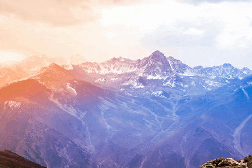 a view of a mountain range with a pink sky