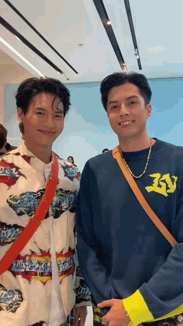 two men are posing for a picture and one of them is wearing a shirt that says lv