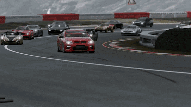 a group of cars are driving on a road with a red car in the middle