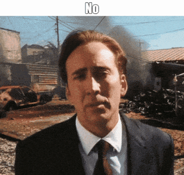 a man in a suit and tie says no in front of a destroyed area