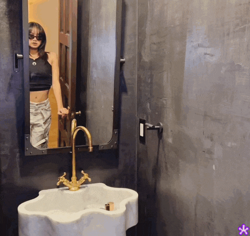 a woman is taking a selfie in a bathroom mirror