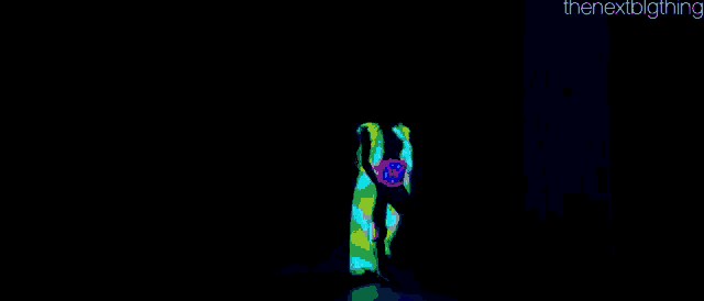 a person is dancing in a dark room with glow in the dark clothes on .