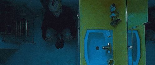 a person is sitting on a toilet in a bathroom with a sink .