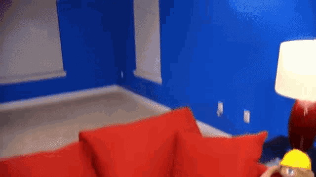 a red couch in a living room with blue walls