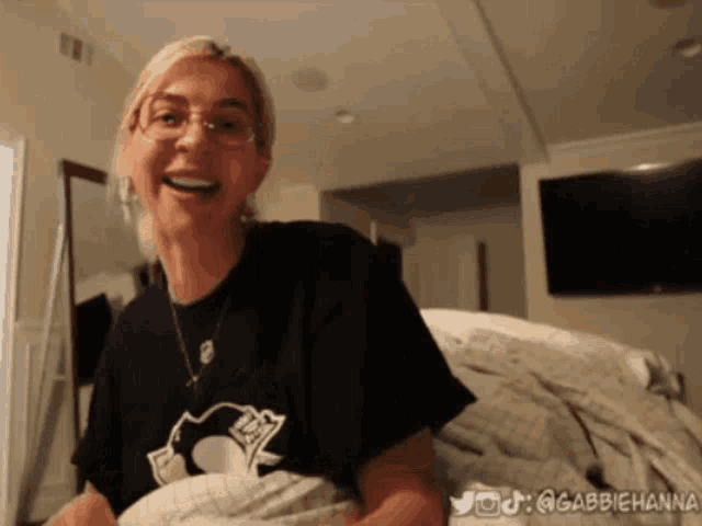 a woman wearing a black shirt with a penguin on it smiles