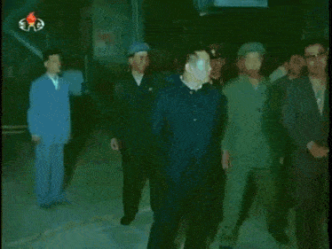 a group of men standing in front of a building with a sign that says ' a ' on it