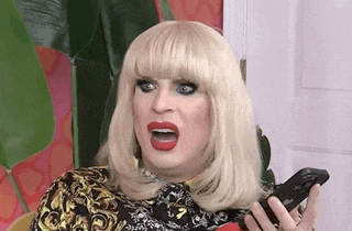 a woman with blonde hair and red lips is holding a cell phone .