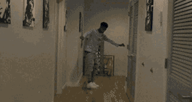 a man in a striped shirt is standing in front of a door with a sign on the wall that says " the "