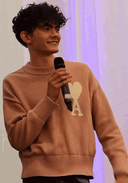 a man in a pink sweater with the letter a on it
