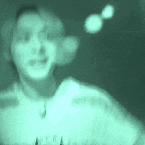 a blurry picture of a person 's face in a dark room with a green background .