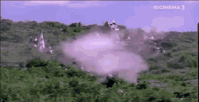 a large explosion is taking place in the middle of a field with a castle in the background .