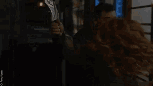a man and a woman are sitting next to each other in a room with a lamp .