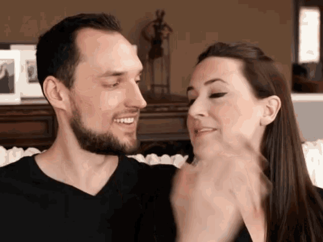 a man and woman are touching each other 's faces