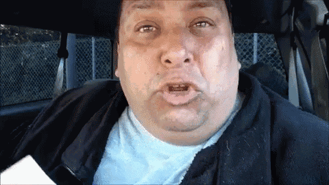 a man making a funny face while sitting in the back seat of a car