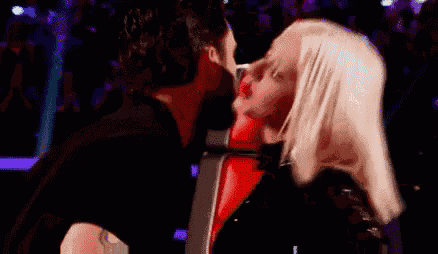 a man and a woman are kissing each other in a dark room .