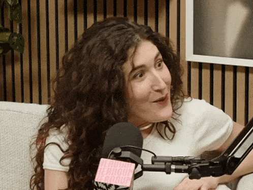 a woman is sitting in front of a microphone with a tag that says ' headbutt headbutt ' on it