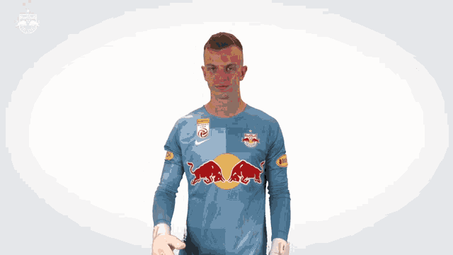 a man is wearing a blue jersey with a red bull on it