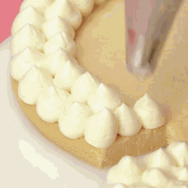 a close up of whipped cream being piped on a piece of cake