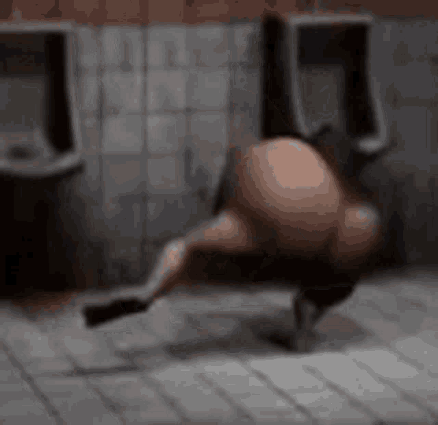 a cartoon character is doing a handstand in a bathroom .