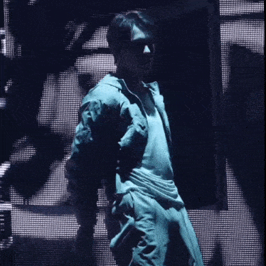 a man in a white shirt is standing in front of a screen