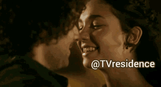 a man and a woman are kissing in front of a sign that says tv residence
