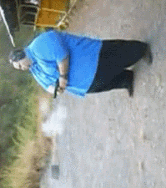 a man in a blue shirt is kneeling down on the ground