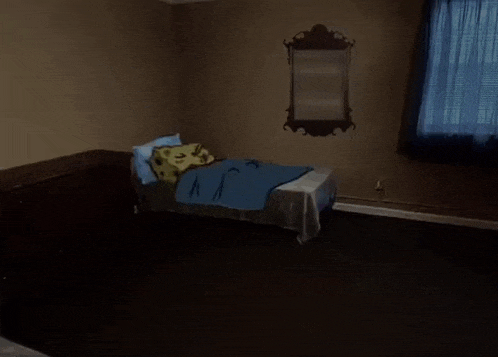 a bedroom with a bed and a mirror hanging on the wall