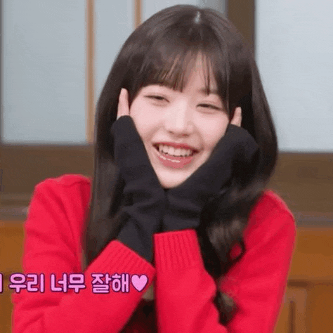 the girl is wearing a red sweater and black gloves and smiling .