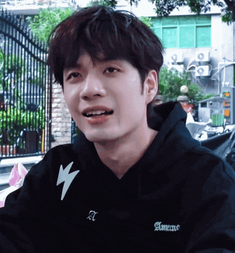 a young man wearing a black hoodie that says amens on it