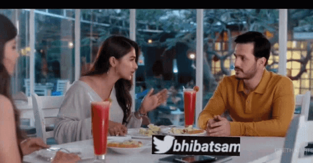 a group of people are sitting at a table with a sign that says bhibatsam