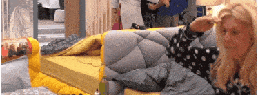 a woman in a black and white polka dot shirt is sitting on a couch