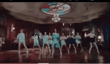 a group of girls are dancing in a room with a stained glass ceiling .