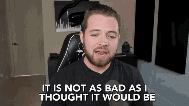 a man with a beard is sitting in a gaming chair and says it is not as bad as i thought it would be .