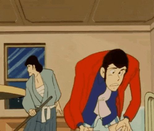 a man in a red jacket is standing next to another man in a blue shirt .