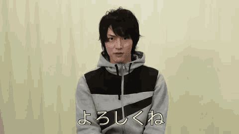 a young man is wearing a hoodie and making a face .
