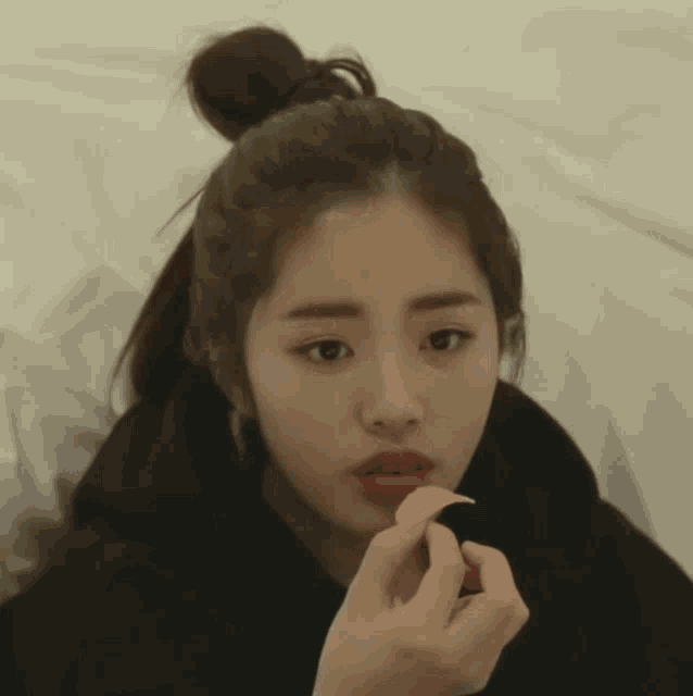 a woman in a black hoodie is eating chips